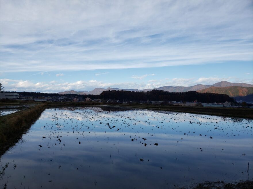 富士吉田市農村公園の水のはってある田んぼと空